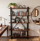 Librero industrial Celta 120 con libros, fotografías y plantas junto a un escritorio.