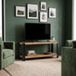 Mueble para TV BRONTE de madera clara y acero negro, con televisor y objetos decorativos en la repisa inferior.
